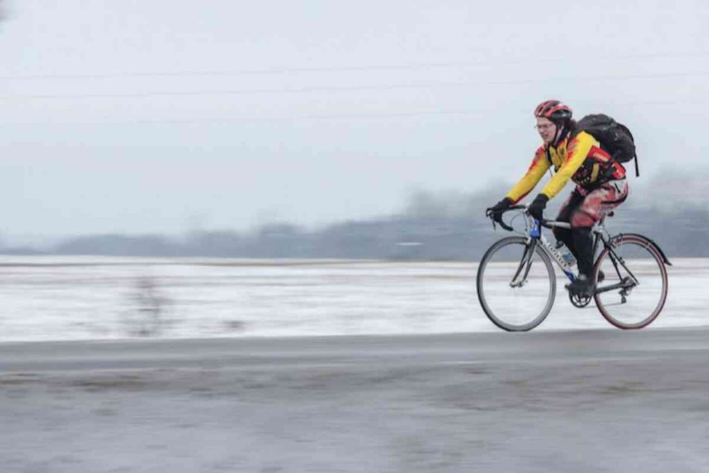 Homem pedalando no inverno